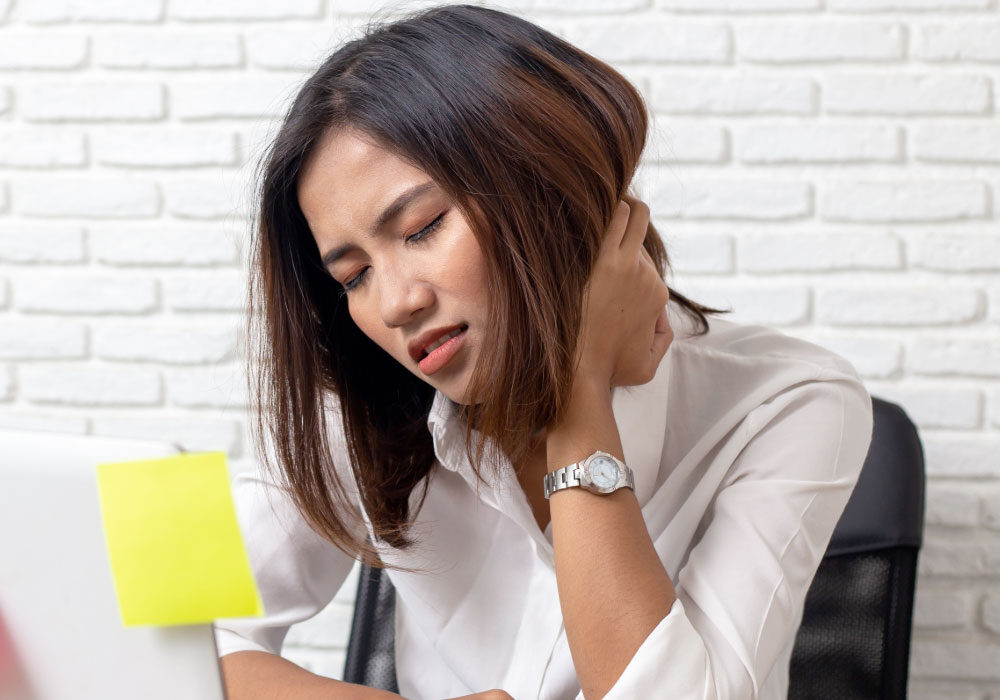 Deskbound employee suffering neck pain