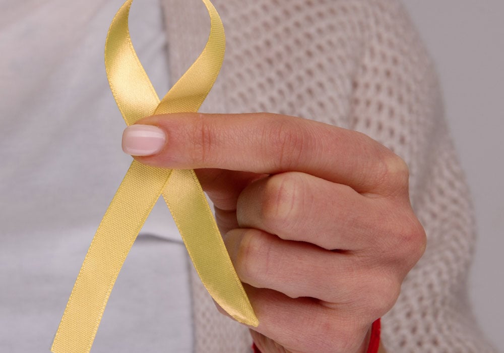 hand holding a yellow empathy ribbon